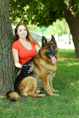 Beautiful young girl with dog in park