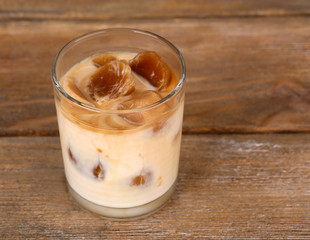 Iced coffee in glass on wooden background