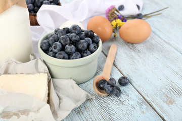 Fresh blueberries and milk products on wooden table