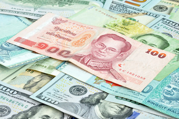 Money in multi currencies - 100 Thai Baht bill on top