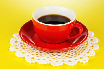 A red cup of strong coffee on yellow background