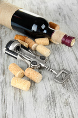 Corkscrew with wine corks and bottle of wine