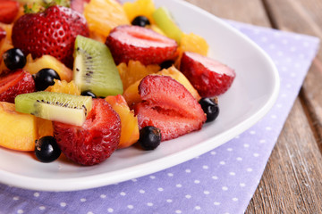 Fresh fruits salad on plate with on table close up