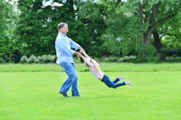 Fototapeta na wymiar Playful father and daughter having fun in garden