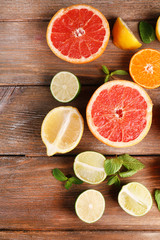 Different sliced juicy citrus fruits on wooden table