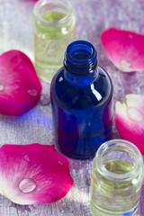 Obraz na płótnie Canvas Aromathérapie- bouteille huiles essentielles et petales de rose