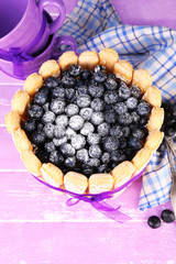 Tasty cake Charlotte with blueberries on wooden table
