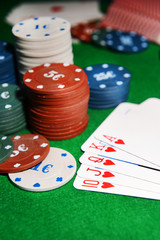 Cards and chips for poker on green table