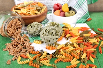 Variety of colorful pasta on wooden background
