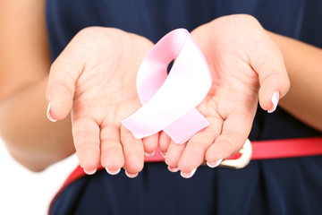 Fototapeta premium Woman with aids awareness pink ribbon in hands isolated on