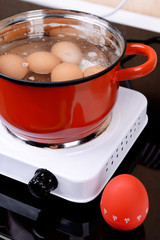 Eggs in boiling water in pan on electric hob