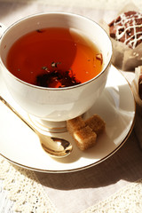 Cup of tea with cupcakes on table, close up