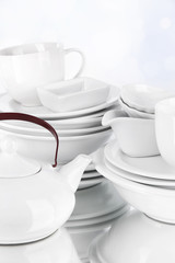 White crockery and kitchen utensils, on light background