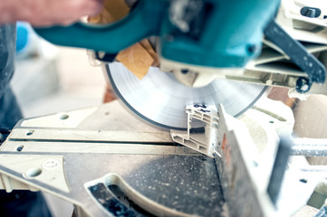 worker or handyman cutting PVC profile with circular saw