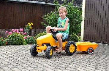 Kind im Sommer fährt Traktor © alisseja