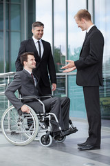 Disabled businessman talking with his co-workers