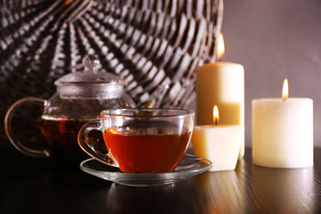 Composition with tea in glass teapot and candles