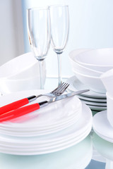 Set of white dishes on table on light background