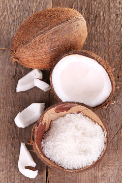 Broken coconut on wooden background