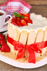 Tasty cake Charlotte with fresh strawberries on wooden table