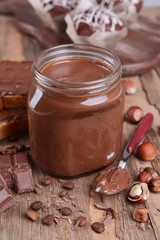 Sweet chocolate cream in jar on table close-up