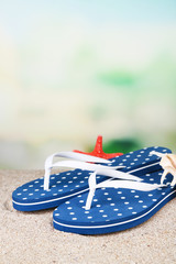 Color flip-flops on sand, on nature background