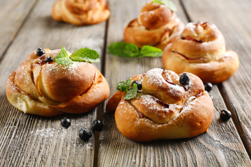 Tasty buns with berries on table close-up