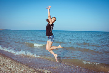 Young cheerful girl on the sea