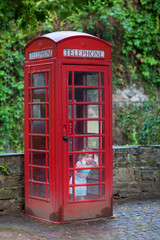 Little girl in a telephone booth