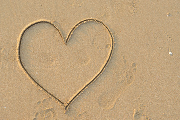 heart symbol written in the sand close view