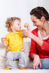 Child eating and mother helping