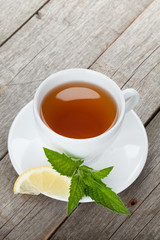 Green tea with lemon and mint on wooden table