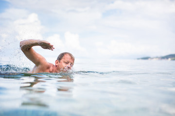 Senior man swimming in the Sea/Ocean