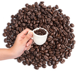 Cup of coffee beans on coffee beans background