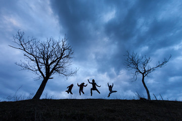 Happy people jumping over the clouds