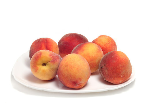 seven ripe peaches on a plate