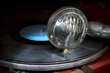Head with an old gramophone needle on the vinyl disc © plus69