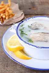 Tasty soup with oysters on wooden table