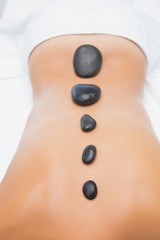 Beautiful woman receiving stone massage at spa center