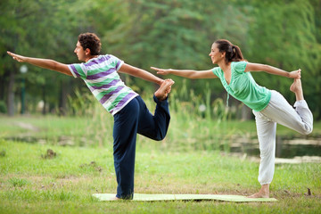 Couple practising yoga in park