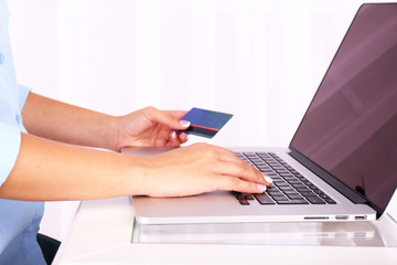 Female hands working on laptop, on light background