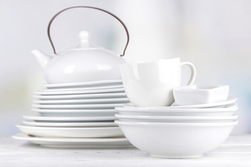 White crockery and kitchen utensils, on light background