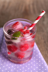 Cold cocktail with forest berries, frozen in ice cubes