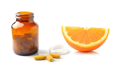 Orange fruit with vitamin c tablet on white background