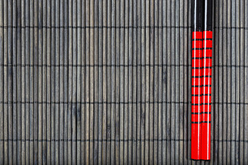 Two chopsticks on sushi mat background