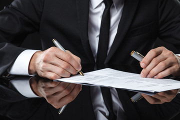 Extreme close up of female business hand signing document.