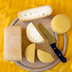 Assorted cheeses on old wooden board, farm produce