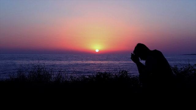 Man Praying by the Sea at Sunset