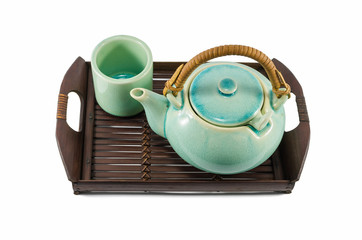 Chinese green teapot and teacups on the wooden trivet isolated