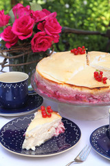 Käsekuchen mit frischen Johannisbeeren auf einer Kaffeetafel